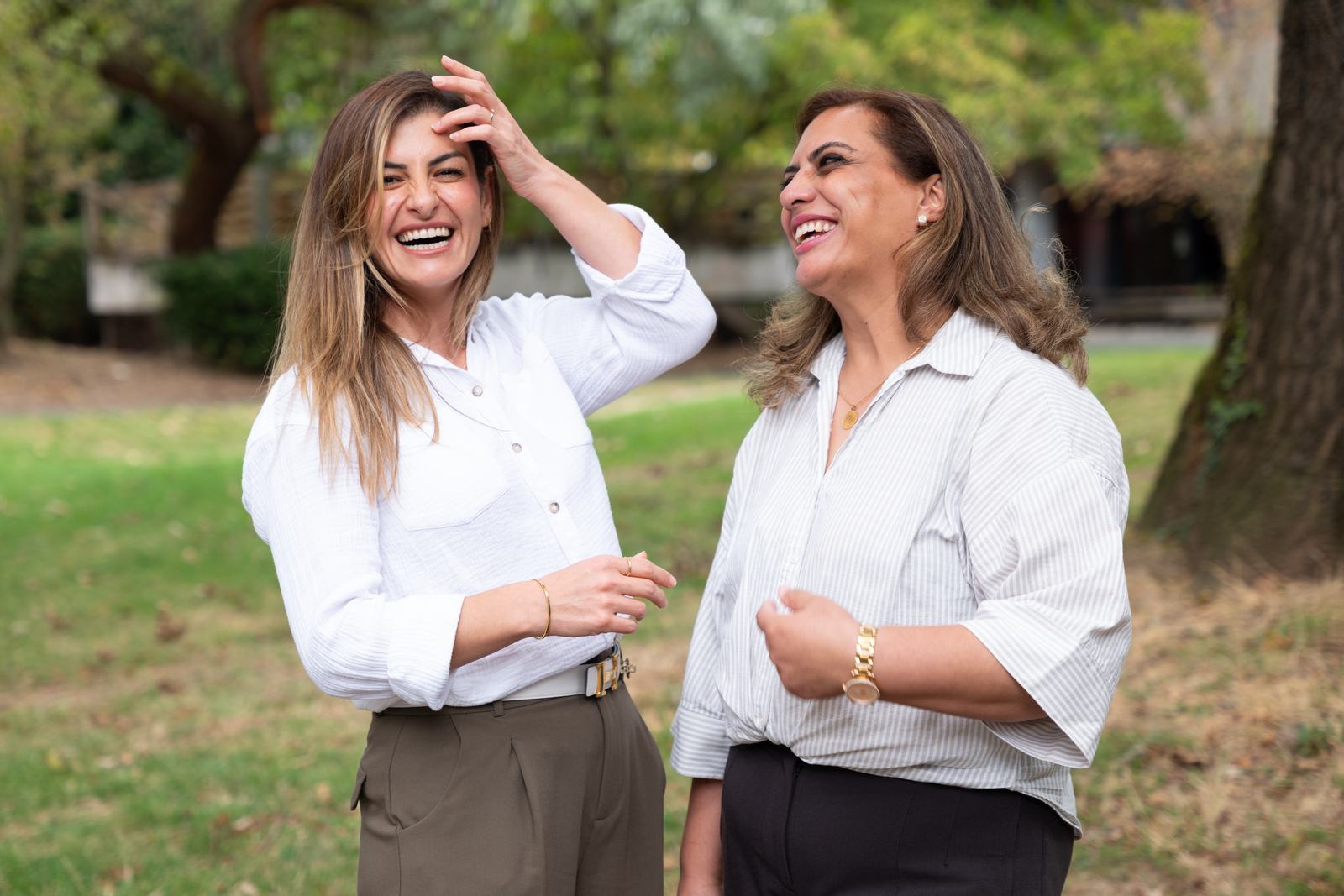 Zwei Kolleginnen lachen gemeinsam im Park